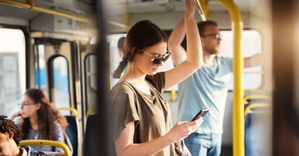 Mujer con teléfono móvil en transporte público