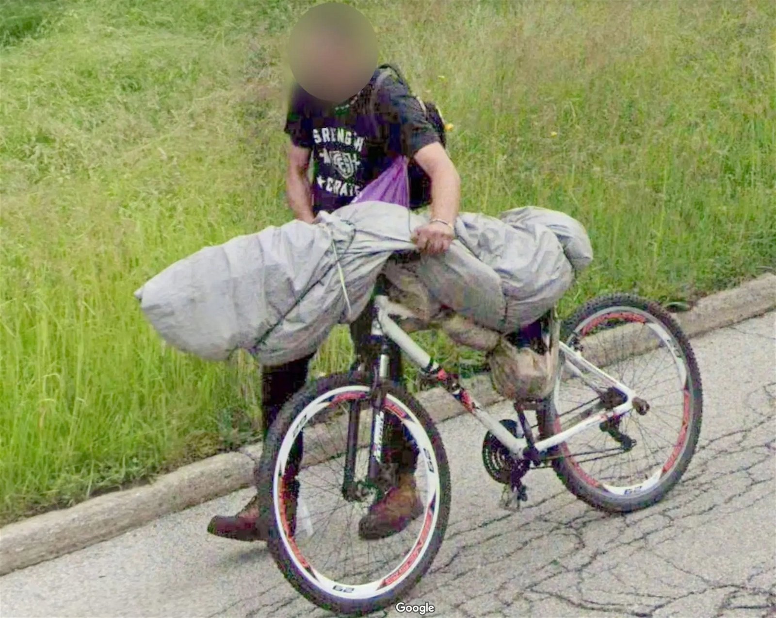  Una persona lleva lo que supuestamente es un cadáver en su bicicleta