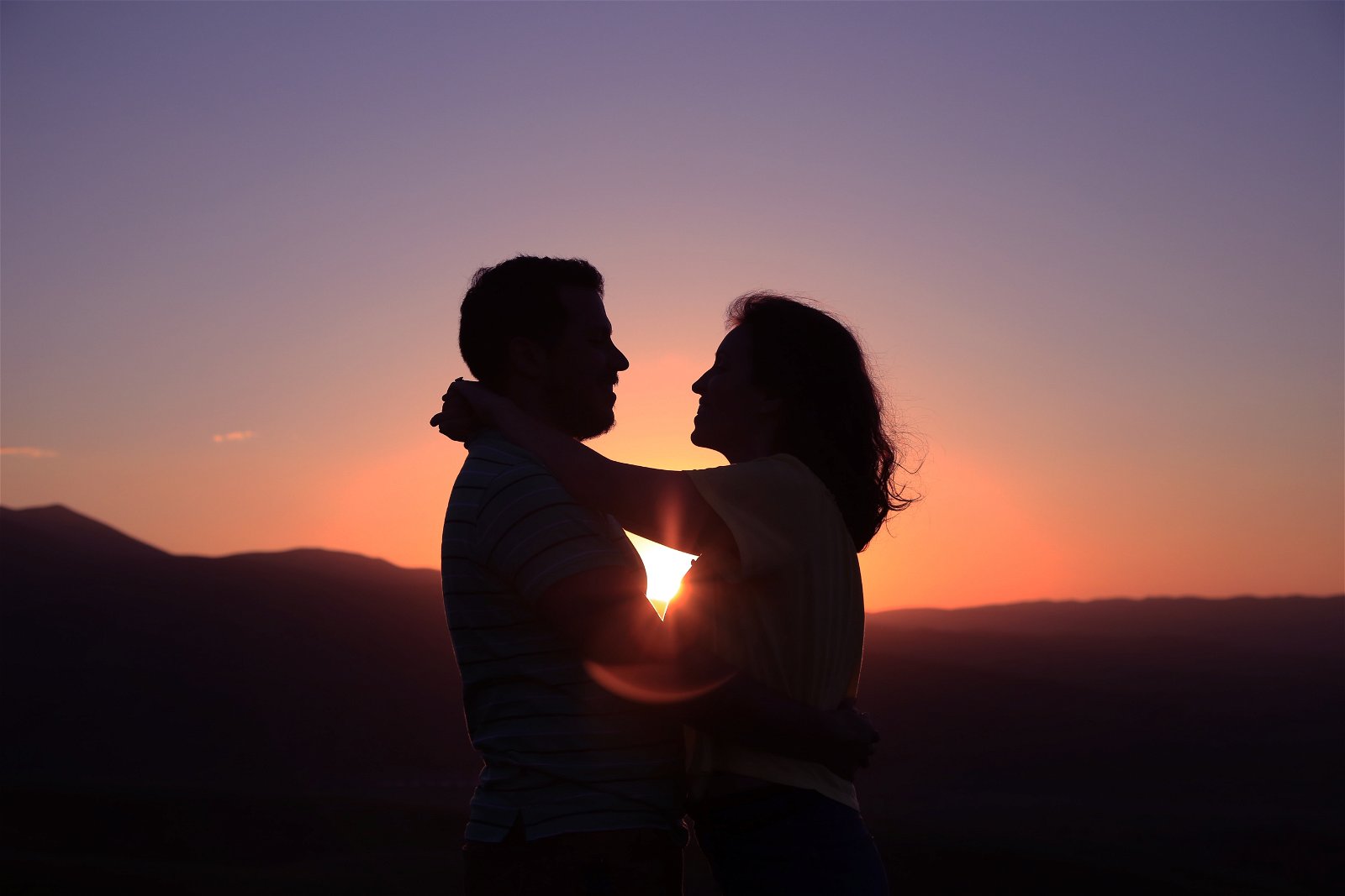 una pareja abrazada en una puesta de sol