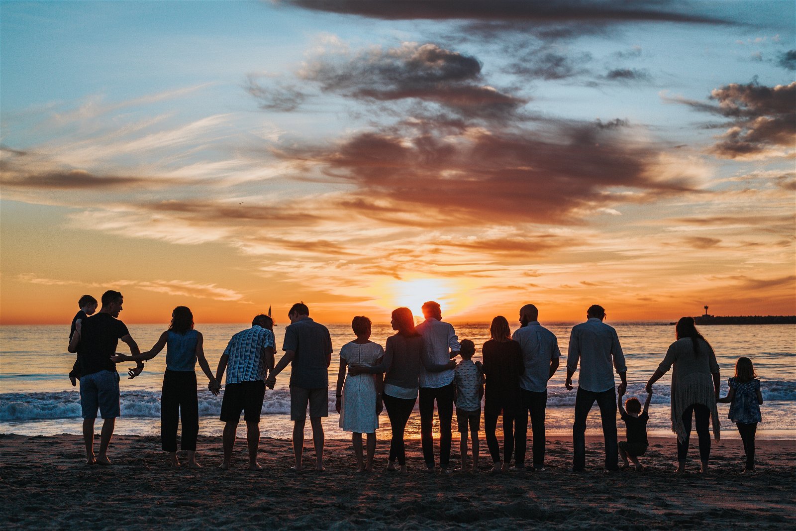 una familia en la playa durante la puesta de sol
