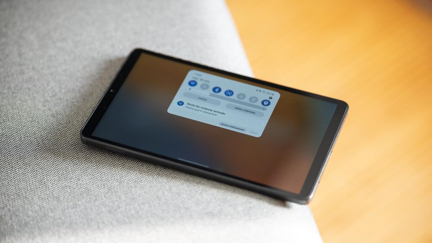Samsung Galaxy Tab A9 con la barra de tareas desplegadas sobre un asiento gris