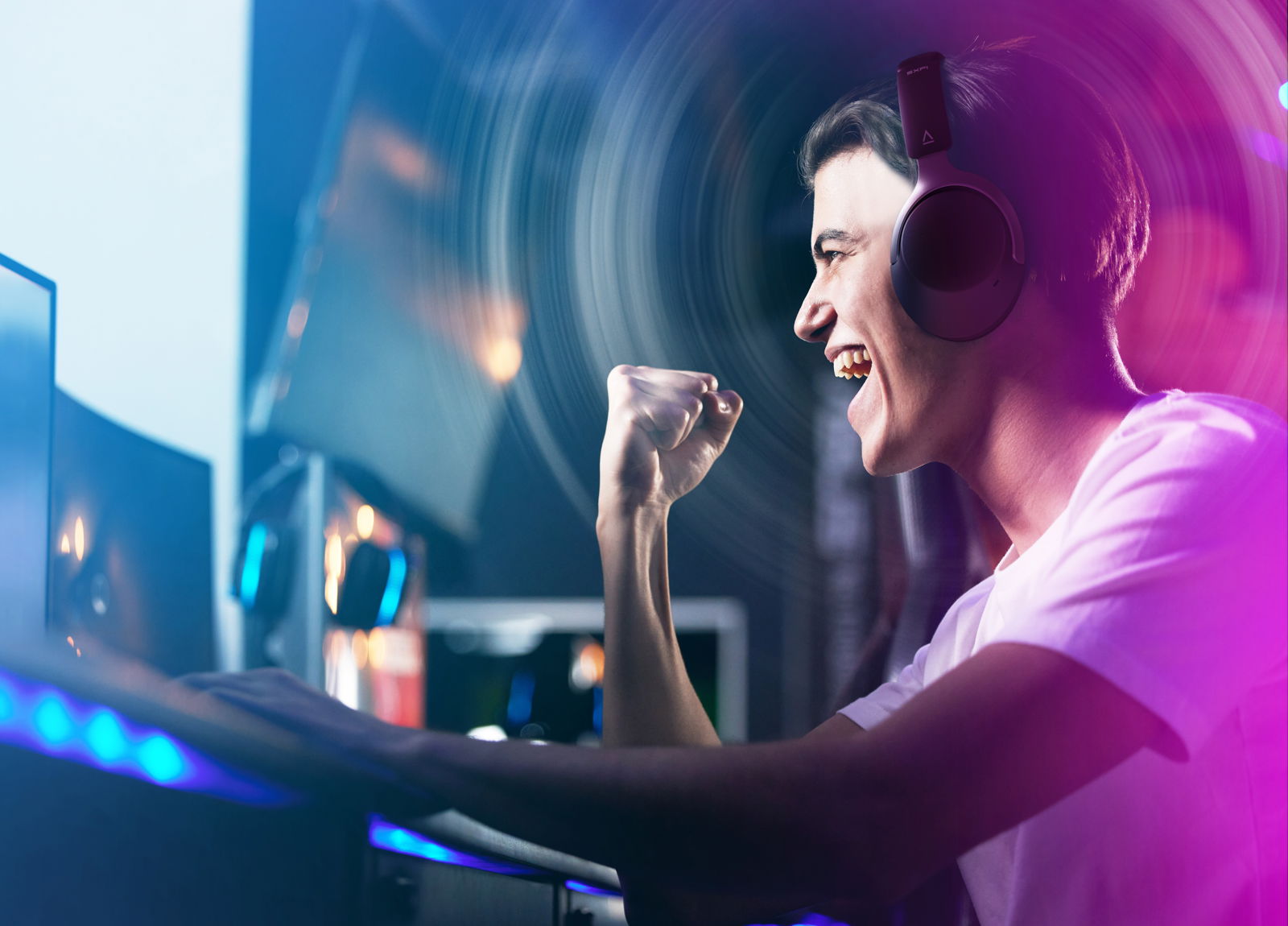 un hombre celebra con el puño en alto una victoria en un juego electrónico llevando unos auriculares zen hybrid  sfxi
